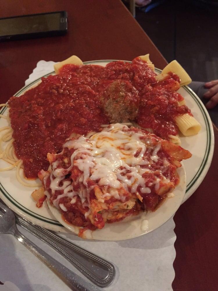 Italian Plate · A side of spaghetti, a meatball, a ravioli, a side of rigatoni and a side of lasagna, smothered in our house made meat sauce. Add baked mozzarella for an additional charge.