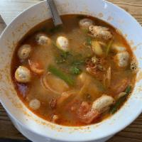 Tom Yum · Spicy and sour soup with mushroom, tomatoes, onion, kaffir lime leaves, galangal root, and l...