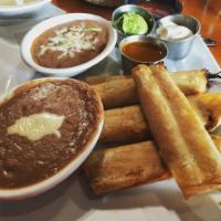 Chicken Flautas · 2 crispy flour tortillas stuffed with chicken & topped with nacho cheese. Served with lettuc...