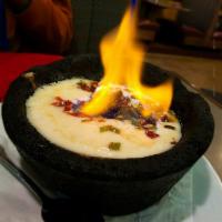 Queso Flameado · Melted Oaxaca cheese topped with chorizo, grilled peppers and onions. Served flaming with wa...