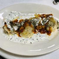 Mantu · Steamed dumplings stuffed with ground beef, onions, cilantro and spices. Topped with our hom...