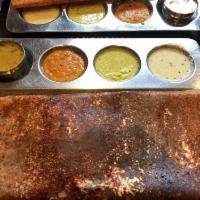 Mysore Masala Dosa · Red chili chutney spread on thin rice and lentil crepe, filled with mashed potatoes and onio...