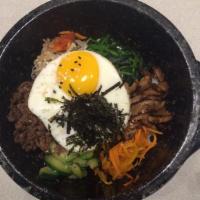Hot Stone Bibimbap · Mixed rice with bean sprout, carrot, zucchini, spinach, and marinated beef served in a sizzl...