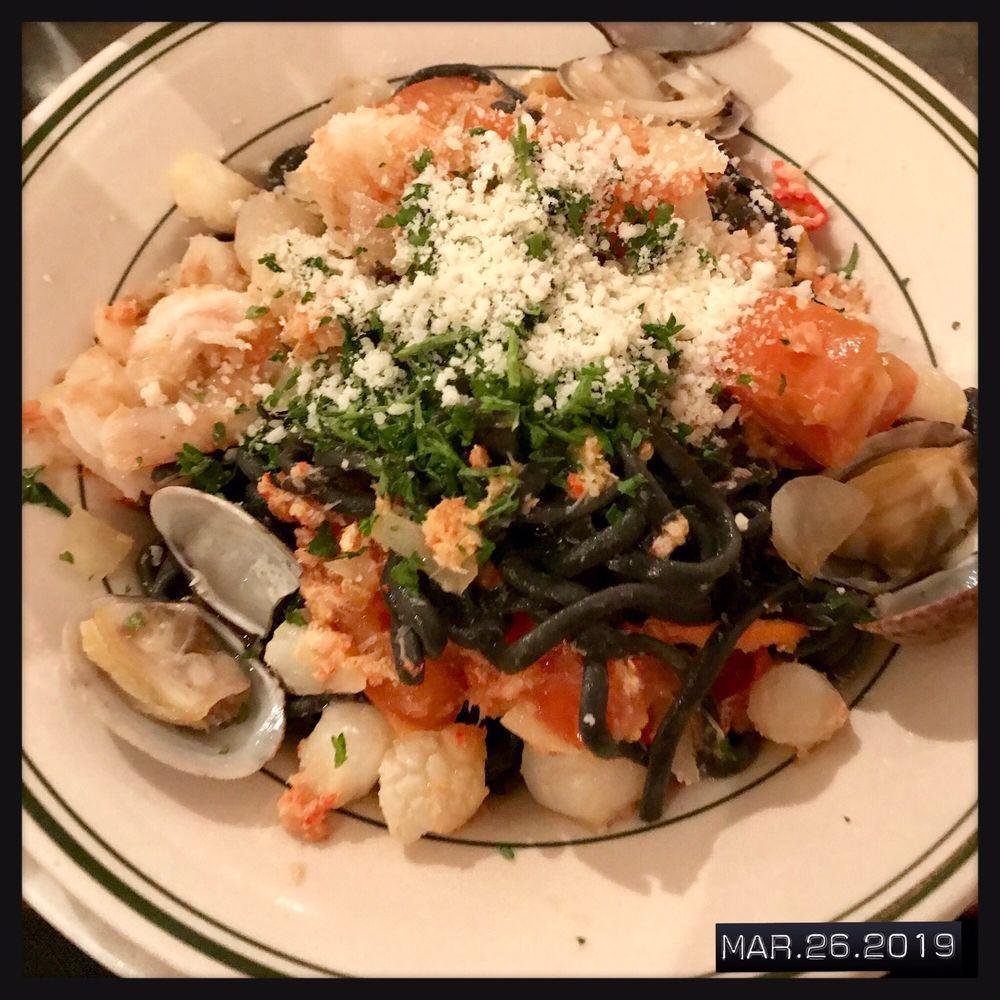 Taglierini Sorrento · Fresh thin black squid ink noodles with shrimp, crab meat, scallops, clams, fresh chopped tomato, parsley, olive oil, white wine and garlic sauce.