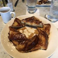 French Toast · Egg bread dipped in cinnamon and sugar, baked and topped with powdered sugar. Served with bu...