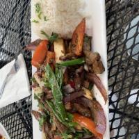 Lomo Saltado · Filet mignon sauteed with onions, tomatoes, soy sauce, vinegar, and Peruvian spices, served ...