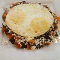 Chilaquiles Poblanos · Traditional dish of fried tortilla strips cooked in roasted tomatoes and pasilla chiles. Ser...