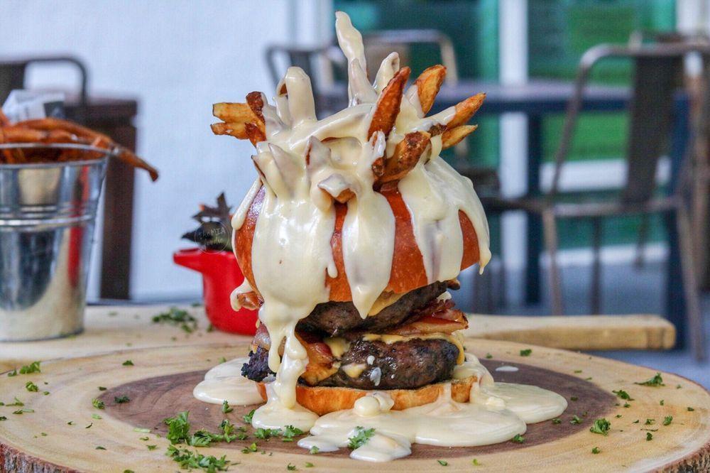 The Fondue Burger · French fries on a top of the buns, 2 beef patties, caramelized onions and our cheese fondue on the top.