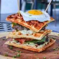 The Waffle Burger · Triple decker waffle bacon cheeseburger, 2 beef patties, 2 eggs sunny side up, salad tomato ...