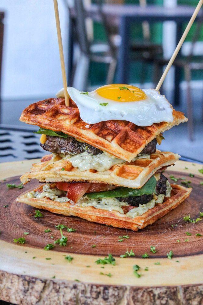 The Waffle Burger · Triple decker waffle bacon cheeseburger, 2 beef patties, 2 eggs sunny side up, salad tomato cheddar and Swiss cheese and our homemade tartar sauce.