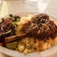 Mandi · Oven roasted lamb shank mixed with special spices served with rice topped with roasted almon...