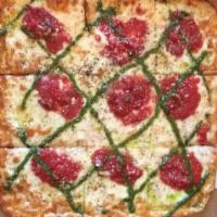 Paesano Pizza · Tomato pie style with crushed tomatoes, roasted garlic, mozzarella, drizzled with pesto sauce.
