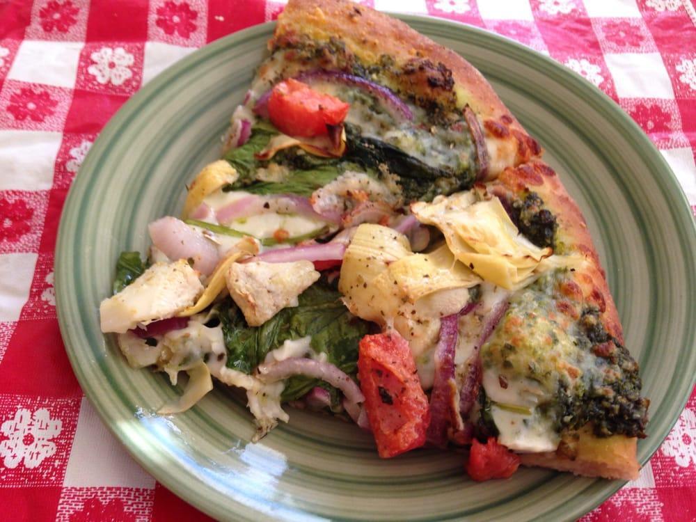 Spring Veggie Pizza · Thin crust with basil pesto, whole milk mozzarella, spinach, red onions, fresh tomatoes, artichoke hearts, and our own Italian Parmesan seasoning.