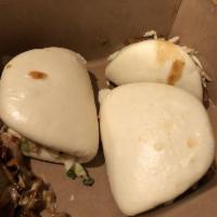 Lechon Steamed Buns · 3 pieces. Crispy skin pork, jicama slaw, sweet and spicy cucumbers, cilantro and dragon sauce.