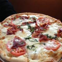 Parma Prosciutto Pizza · White pizza with imported Parma prosciutto, sliced tomatoes, fresh & dry mozzarella, fresh b...