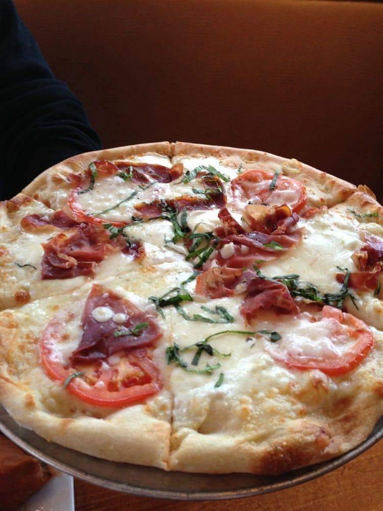 Parma Prosciutto Pizza · White pizza with imported Parma prosciutto, sliced tomatoes, fresh & dry mozzarella, fresh basil