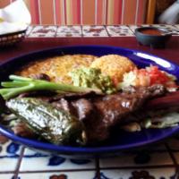 Carne Asada · Thin slices of skirt steak cooked over charcoal. Served with guacamole, rice, refried beans ...
