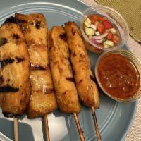 Satay · Skewers of grilled chicken with peanut sauce and cucumber salad.