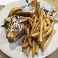 Monte Cristo Sandwich · Fresh slices of turkey breast, ham, and Swiss cheese on egg bread, dipped in egg batter and ...