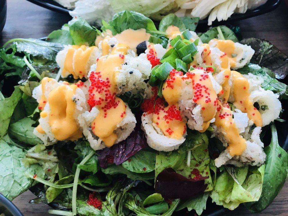 Crispy Calamari Salad · Crispy calamari drizzled with sweet spicy mayo, tobikko, and green onions on a bed of organic greens from Kahumana Farms tossed with a ponzu vinaigrette.