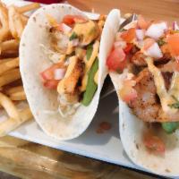 Grilled Shrimp Tacos · Grilled chili marinated shrimp in warm flour tortillas served with pico de gallo, avocado sl...
