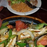 Chicken Fajitas · Marinated chicken grilled with peppers, onion and tomato served with guacamole and pico de g...