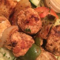 Chicken Kabob · Two skewers. Served over garnished basmati rice and topped with garlic tahini sauce and one ...