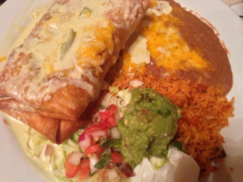 Chimichanga · Flour tortilla filled with your choice of bean and cheese, shredded beef, ground beef, savory chicken or our flavorful slow cooked carnitas, fried until crisp, follow by zesty red sauce, served with fresh guacamole, sour cream, lettuce, and tomatoes. Served with Mexican rice and refried beans.