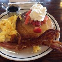 Buttermilk Pancakes with Eggs and Bacon · Four fluffy buttermilk pancakes with butter and vanilla maple syrup. Served with a side of b...