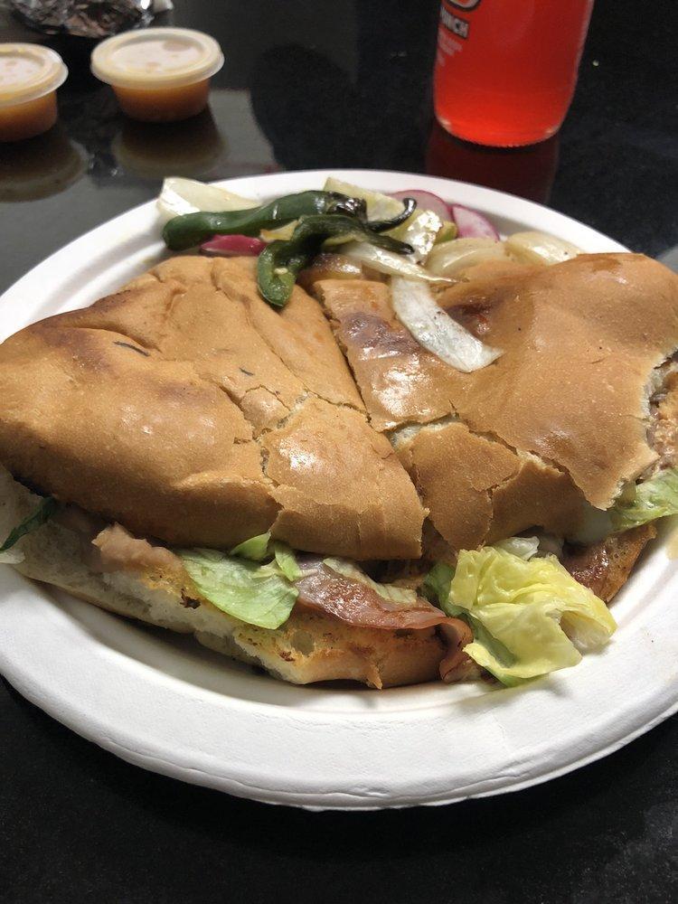 Torta Hawaiana · Telera toasted with cheese and a base of refried beans and ham. Includes pineapple, lettuce, tomato, cilantro, onion, sour cream, cheese and salsa.