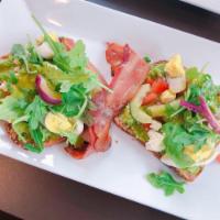 Loaded Avocado · Avocado, bacon, cucumber, tomato, sunflower seeds, sunny side up eggs, chipotle sauce on mul...