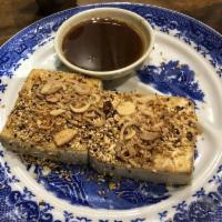 Tofu Steak · Roasted tofu with fermented soy bean sauce topping with fried shallot and fried garlic.