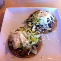 Sope · Thick corn tortilla cup filled with refried beans, lettuce, cheese and sour cream.