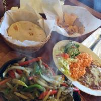 Fajitas · Chunks of grilled meat with bell pepper and onions, side of freshly made guacamole and rice ...