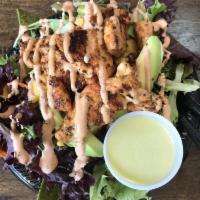 Smokey Mexican Bonanza Salad · Spring mix topped with grilled Adobo Chicken, black bean, corn and mango salsa on a bed of h...