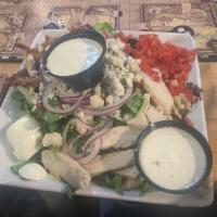 Cobb Salad · A hearty Cobb salad with fresh mixed greens, bacon, tomatoes, onions, Bleu cheese crumble, c...