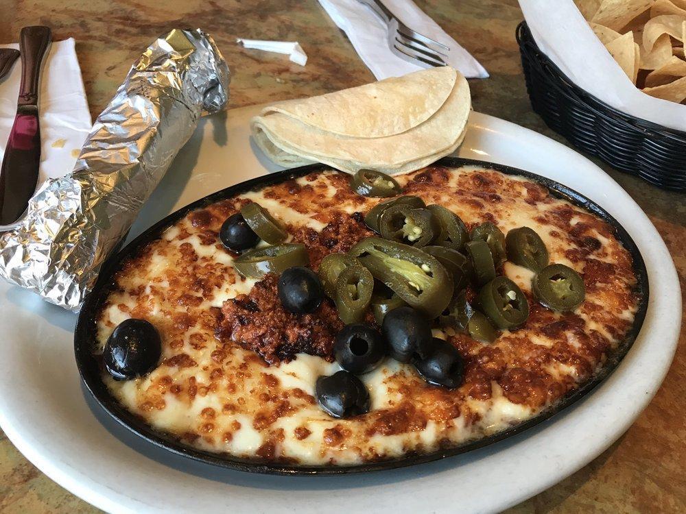Queso Fundido · Baked cheese with chorizo, jalapenos and olives, served with warm tortillas.