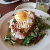 Chilaquiles · Pollo verde with crema and fried egg. 