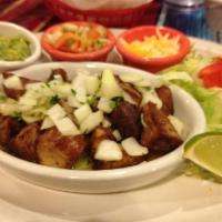 Carnitas · Chunks of marinated fried pork topped with garlic, onions, and cilantro. Served with lettuce...