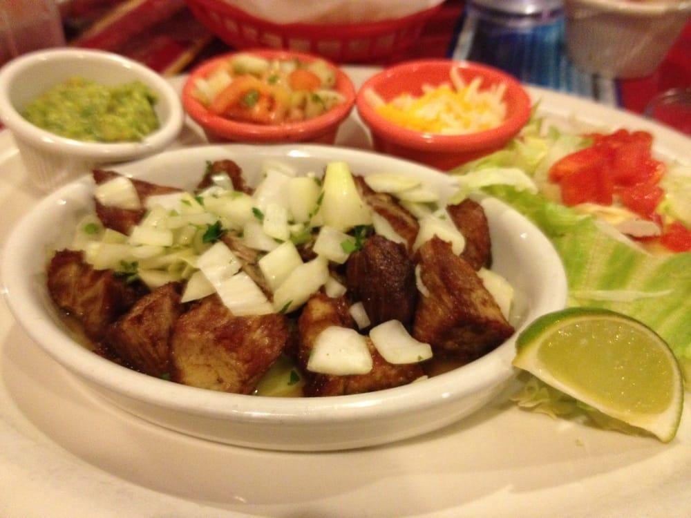 Carnitas · Chunks of marinated fried pork topped with garlic, onions, and cilantro. Served with lettuce, tomatoes, cheese, pico de gallo, guacamole and flour or corn tortillas.
