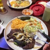 Carne Asada · Seasoned fillets of steak char-broiled and garnished with grilled onions and a jalapeno pepp...