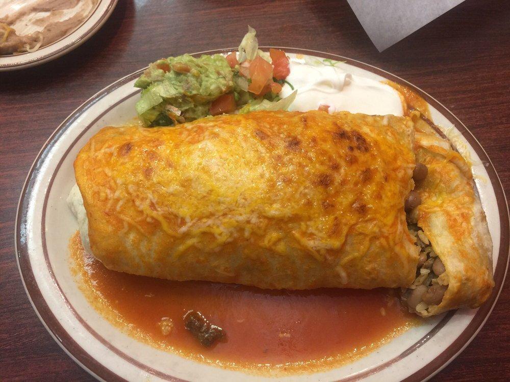 Wet Fajita Burrito · A giant flour tortilla filled with marinated strips of chicken or beef steak meat, sauteed with onions and bell peppers, Mexican rice and rancho, beans. Garnished with guacamole and sour cream. Topped with red sauce and melted cheese.
