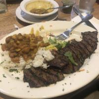 Carne Asada · A delicious 10 oz. wood grilled sirloin flap steak, marinated with our secret spices. Served...