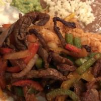 Fajitas · Grilled with green and yellow onions, bell peppers and tomatoes, tortillas and a side of gua...