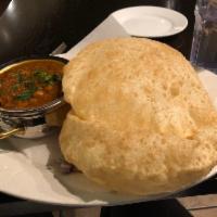 Chole Bhatura · Deep fried puffed flour bread served with spiced garbanzo beans curry.