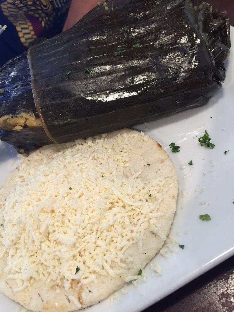 Tamales · A corn cake filled with chicken, pork, potatoes, peas and carrots all wrapped in a banana leaf and cooked by hot steam.