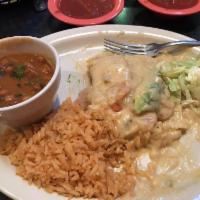 Seafood Enchiladas · 2 cheese enchiladas topped with shrimp, seafood sauce and slices of fresh avocado. Served wi...