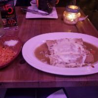 Enchiladas Suizas · Rolled corn tortillas, stuffed with chicken, in our homemade tomatillo sauce, served with Me...