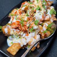 Papri Chaat · Homemade chips with chickpeas, potatoes, onions topped with yogurt, tamarind and mint chutney.