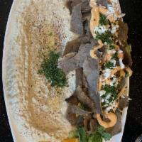 Baba Ghanouj · Smoky roasted eggplant with tahini. Garnish with olive oil and parsley. Served with fresh ba...